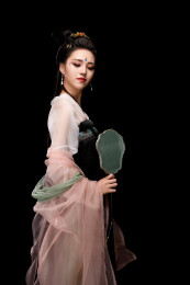 手持轻扇展示唐代服饰妆容造型的东方女性