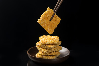 一盘糯米锅巴摆放在桌面上特写