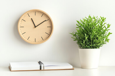 靠墙的桌子上的闹钟和盆栽植物特写镜头