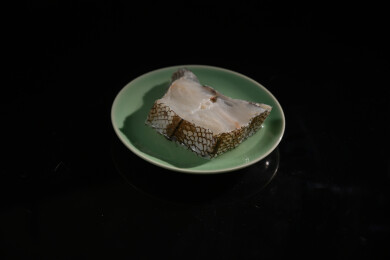 桌面上的盘子里的美味可口的新鲜鳕鱼扒