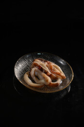 桌面上的盘子里的新鲜的鱿鱼圈