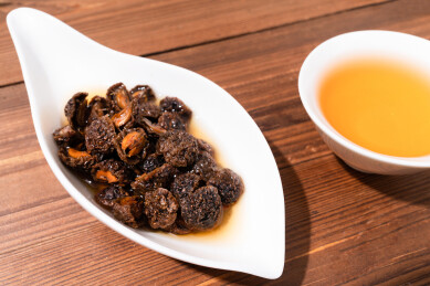 木纹桌上放着余甘果干