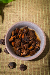 木纹桌上放着余甘果干