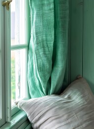 窗边绿色窗帘和靠枕的温馨窗台