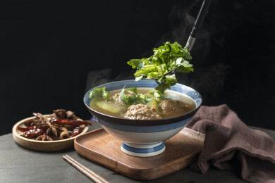 冬瓜丸子汤摆放在木桌面上特写