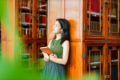 女生书架旁看书