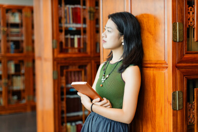 女生书架旁看书