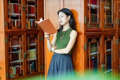 女生书架旁看书