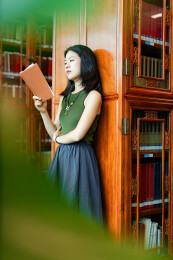 女生书架旁看书