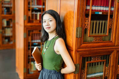 女生书架旁看书