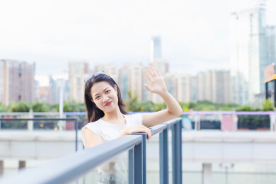 女生在城市建筑广场招手
