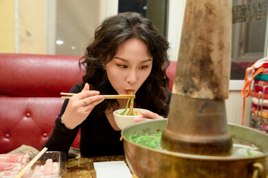 饭店吃传统铜锅涮肉的东方美女