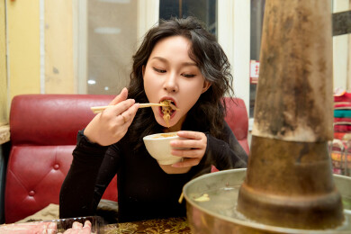 饭店吃传统铜锅涮肉的东方美女