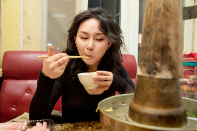 饭店吃传统铜锅涮肉的东方美女
