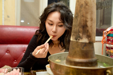 饭店吃传统铜锅涮肉的东方美女