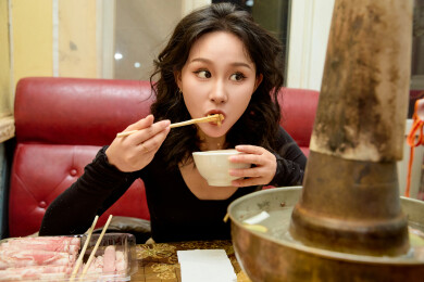 饭店吃传统铜锅涮肉的东方美女