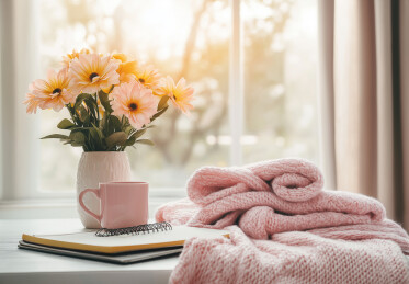 窗户照进室内鲜花与咖啡杯