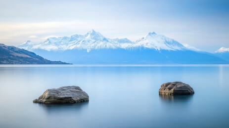 清澈湖泊倒映着壮丽的雪山与蓝天