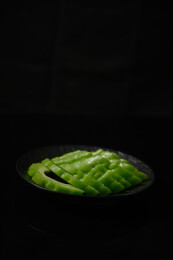 桌面上的盘子里的新鲜的苦瓜片