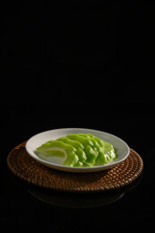 桌面上的盘子里的新鲜的苦瓜片