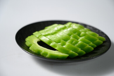 桌面上的盘子里的新鲜的苦瓜片