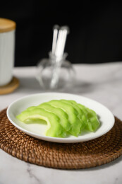 桌面上的盘子里的新鲜的苦瓜片