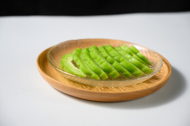 桌面上的盘子里的新鲜的苦瓜片