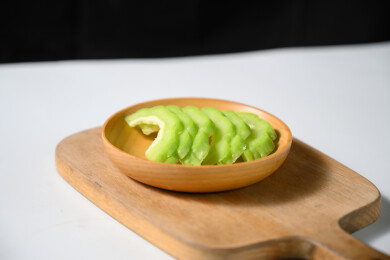 桌面上的盘子里的新鲜的苦瓜片