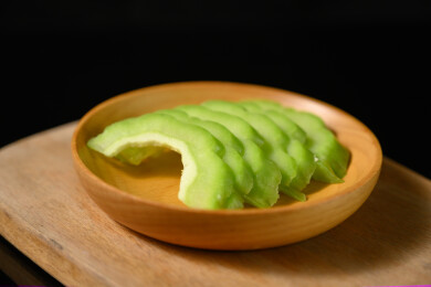 桌面上的盘子里的新鲜的苦瓜片