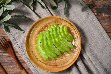 桌面上的盘子里的新鲜的苦瓜片