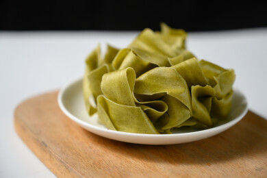 桌面上的盘子里的美味可口的菠菜烩面