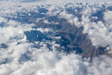 俯拍中国新疆喀什地区云雾缭绕的雪山风景