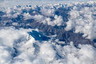 俯拍中国新疆喀什地区云雾缭绕的雪山风景