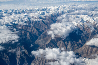 俯拍中国新疆喀什地区云雾缭绕的雪山风景