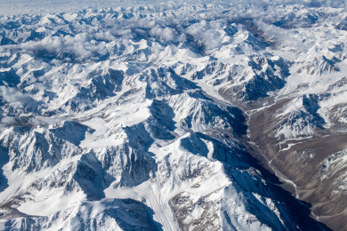 俯拍中国新疆喀什地区云雾缭绕的雪山风景