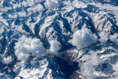 俯拍中国新疆喀什地区云雾缭绕的雪山风景