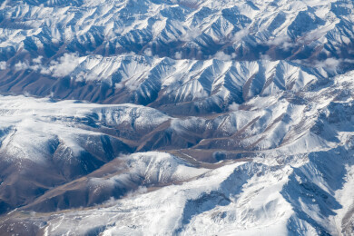 俯拍中国新疆喀什地区云雾缭绕的雪山风景