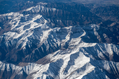 俯拍中国新疆喀什地区云雾缭绕的雪山风景
