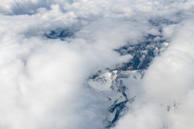 俯拍中国新疆喀什地区云雾缭绕的雪山风景