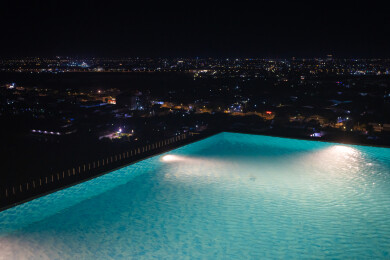 在无边际泳池观看城市夜景风光