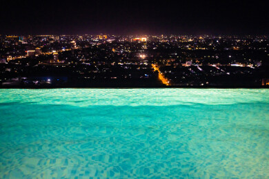 在无边际泳池观看城市夜景风光