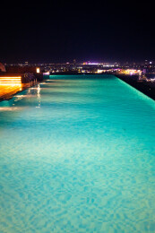 在无边际泳池观看城市夜景风光