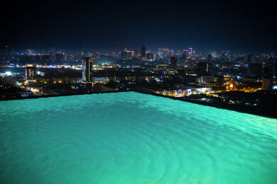 在无边际泳池观看城市夜景风光