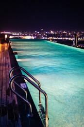 在无边际泳池观看城市夜景风光