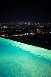 在无边际泳池观看城市夜景风光