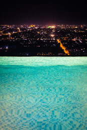 在无边际泳池观看城市夜景风光