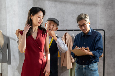 亚洲华裔服装设计师给顾客量体做衣服