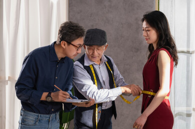 亚洲华裔服装设计师给顾客量体做衣服