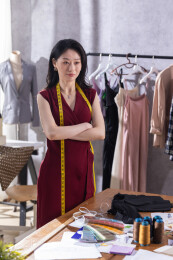 一位年轻女服装设计师站着思考设计方案