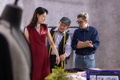 亚洲华裔服装设计师给顾客量体做衣服